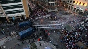 Lebanese protesters chant slogans as riot police fire water cannons following a demonstration, organized by "You Stink" campaign, to protest against the ongoing country's trash crisis on August 23, 2015 in the capital Beirut. Protesters headed back to central Beirut in the morning, joining those who had spent the night there in tents after evening protests spiralled into clashes with security forces. AFP PHOTO / STR (Photo credit should read -/AFP/Getty Images)